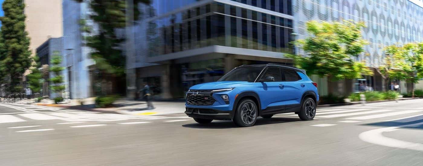 A blue 2025 Chevy Trailblazer RS is shown driving to visit a Chevy dealer near Hampton.