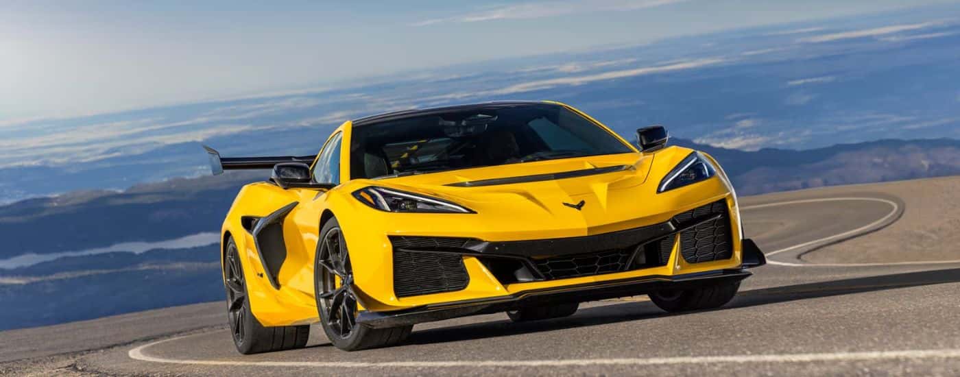 A yellow 2025 Chevy Corvette ZR1 is shown on a winding road after leaving a Chevy dealer near Kittery.