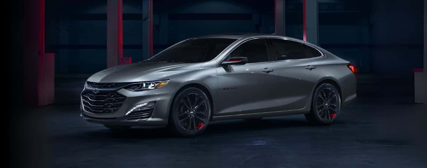 A grey 2024 Chevy Malibu Redline parked in a warehouse.