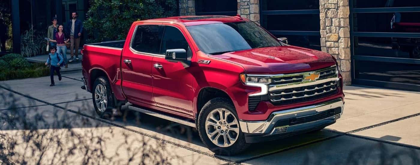 A red 2023 Chevy Silverado 1500 Z71 is shown parked after visiting a Chevy dealer near Stratham.