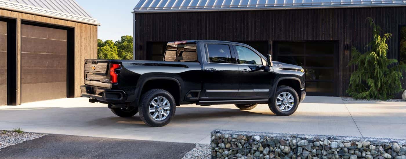 A black 2024 Chevy Silverado for sale near Manchester is shown parked in front of a garage.