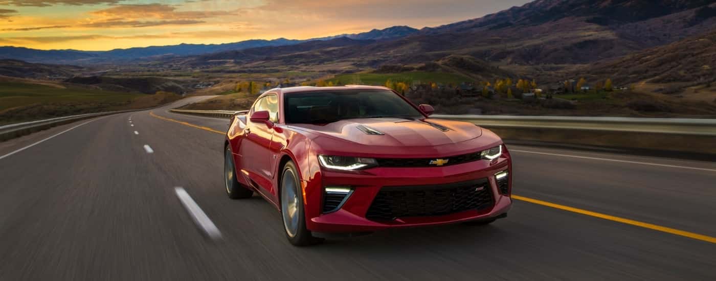 A red 2017 Chevy Camaro is driving on a track after leaving a used car dealer near Newburyport.