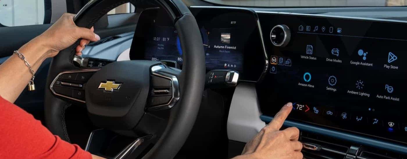 A person using the infotainment screen in a 2025 Chevy Equinox EV for sale near Newton.