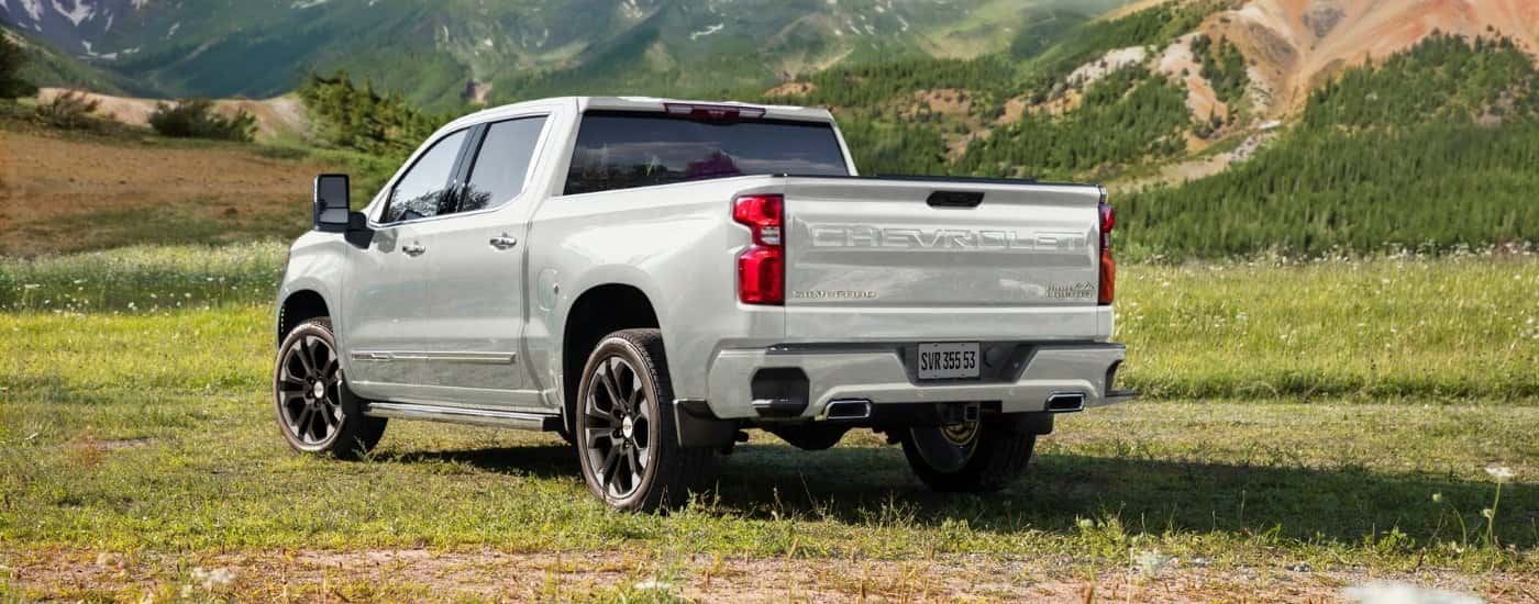 A white 2024 Chevy Silverado 1500 from the rear at an angle after leaving a dealer that has a used Chevy for sale.
