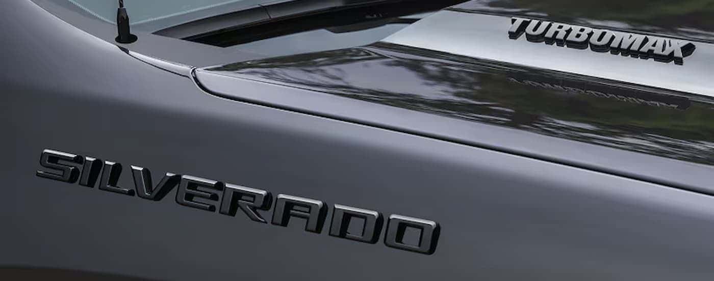 The Silverado badge on a gray 2026 Chevy Silverado 1500.