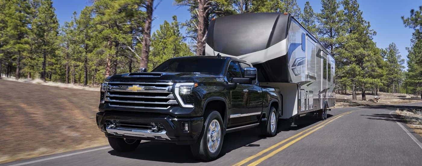 A black 2026 Chevy Silverado 2500 towing a trailer.