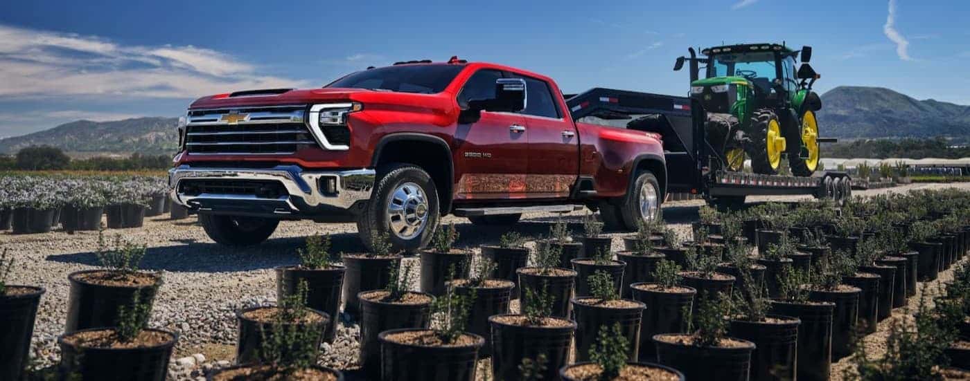 A red 2025 Chevy Silverado 3500 for sale near Newton towing a trailer.