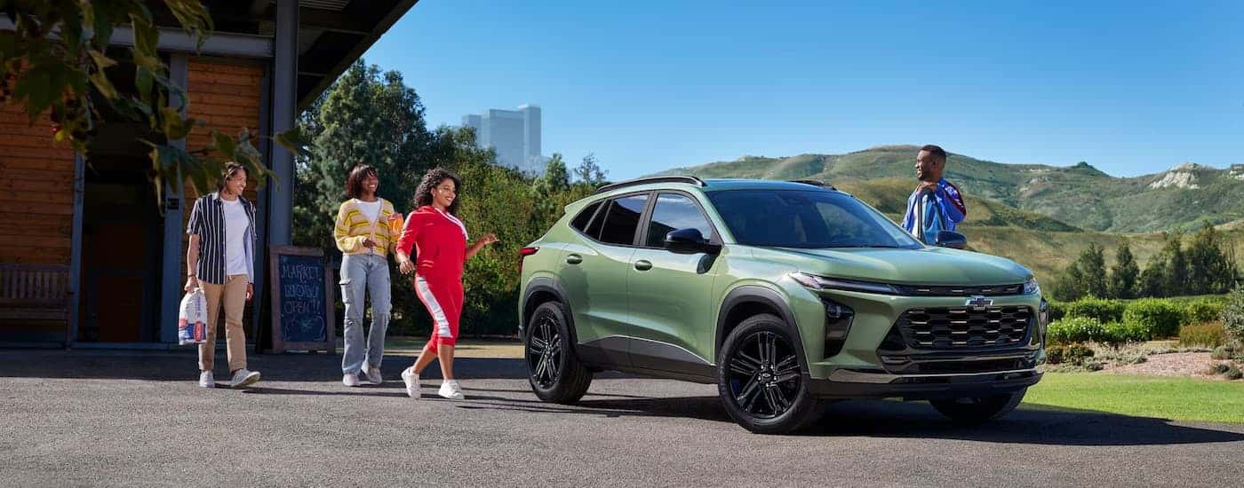 A green 2026 Chevy Trax ACTIV parked near people.