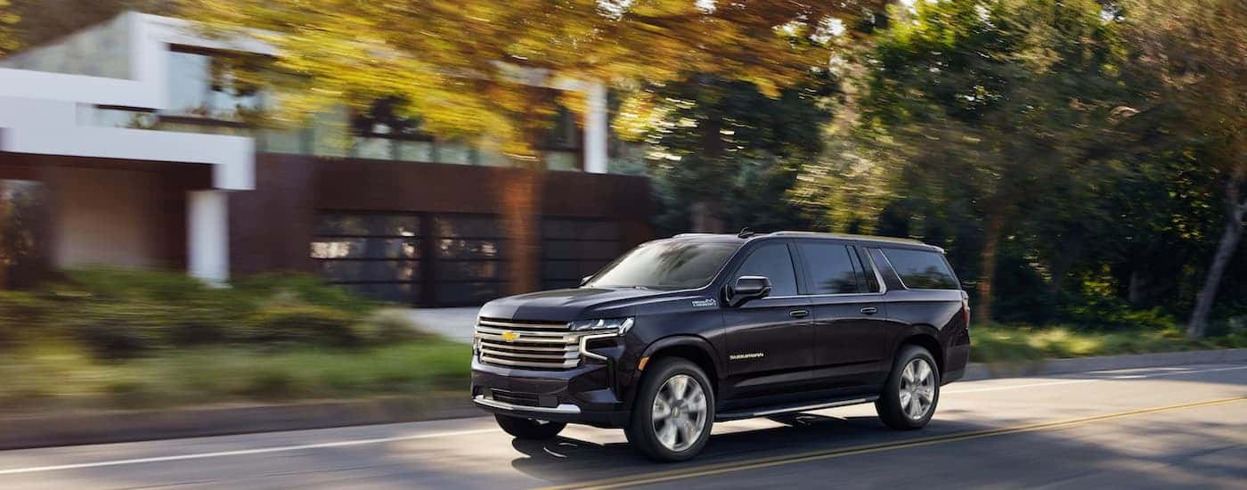 Black 2022 Chevy Suburban driving on a residential road