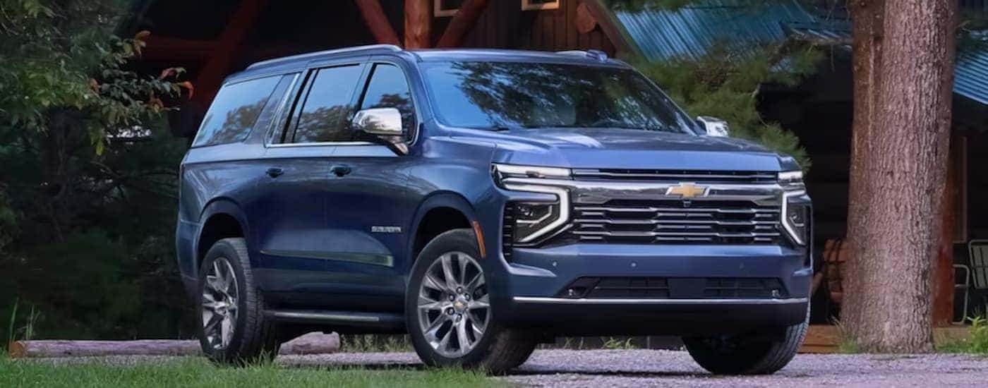 Blue 2026 Chevy Suburban parked in front of a house