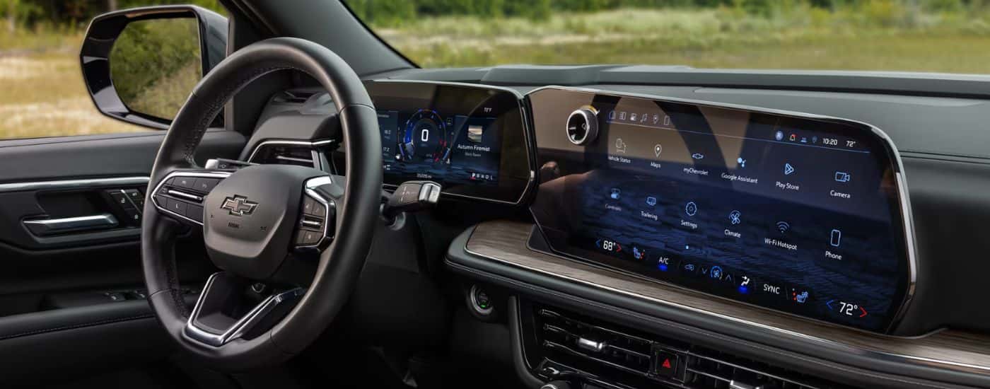 Interior view of a 2026 Chevy Suburban steering wheel, infotainment and digital gauge cluster.