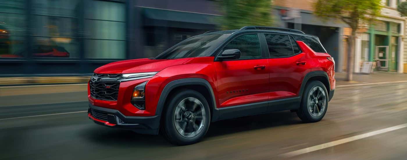 Red 2026 Chevy Equinox driving down a city street