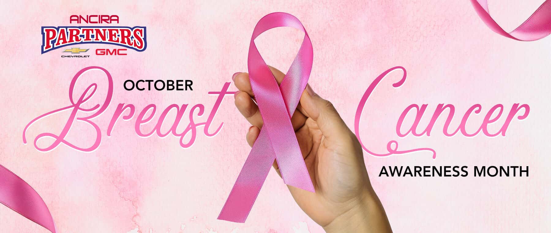 Pink Breast Cancer Awareness Month banner featuring a hand holding a pink awareness ribbon, with the Ancira logo and October Breast Cancer Awareness Month text on a soft pink background.