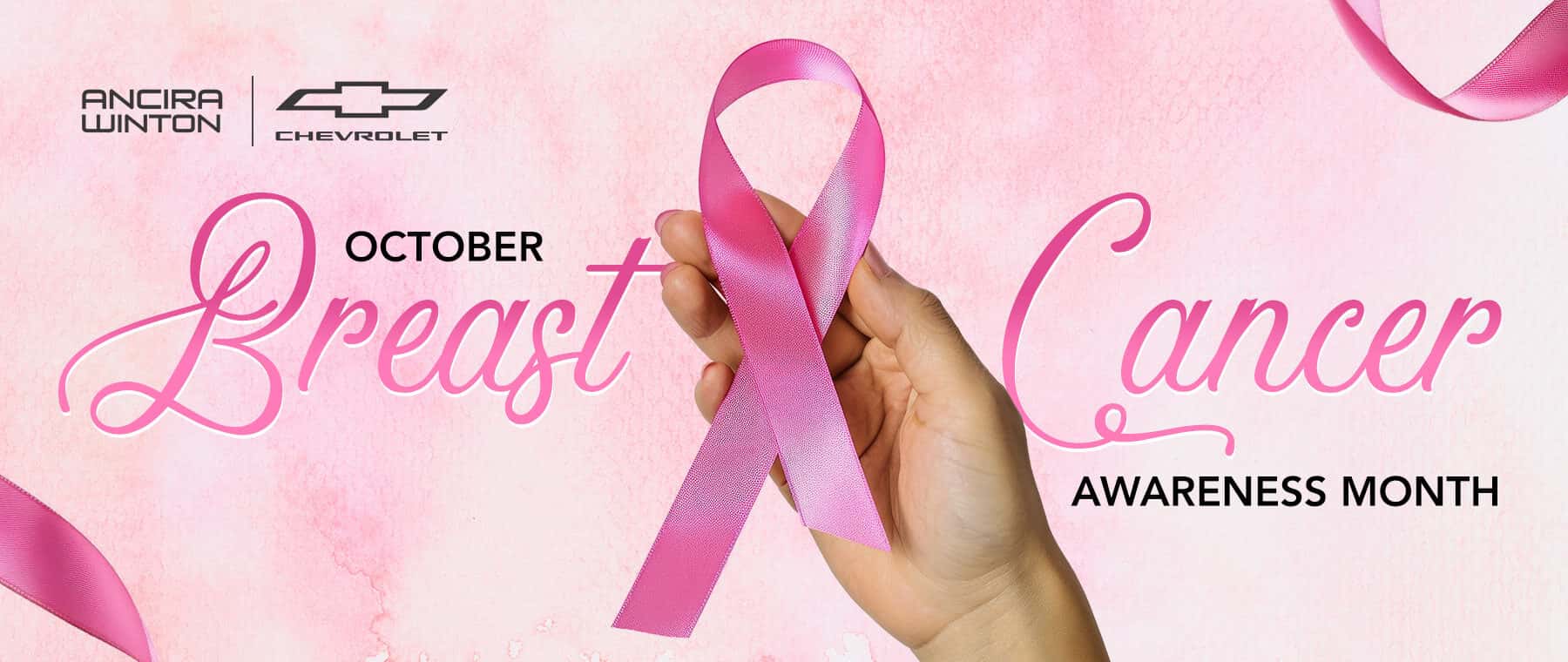 Pink Breast Cancer Awareness Month banner featuring a hand holding a pink awareness ribbon, with the Ancira logo and October Breast Cancer Awareness Month text on a soft pink background.