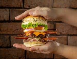photo of a burger between a person's hands 