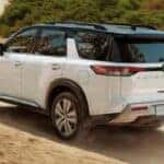 white 2023 nissan pathfinder driving on a dirt road