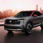 grey 2025 Nissan Kicks parked at an angle in front of a city skyline