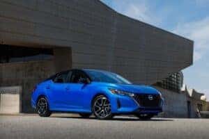 blue 2025 nissan sentra parked outside a modern house