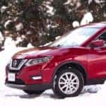 red nissan rogue driving in snow