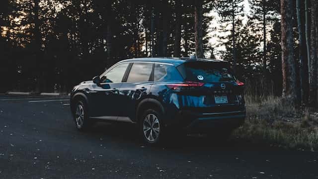 nissan rogue parked in a wooded area