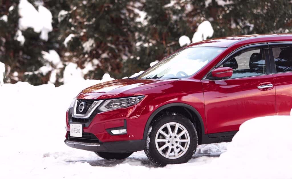 red nissan rogue in the snow