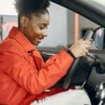 young female teenager holding steering wheel of nissan