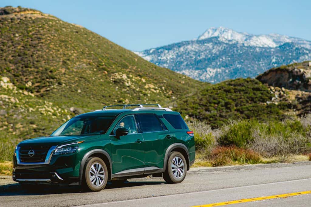 green nissan pathfinder in mountains
