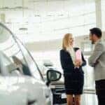 man and woman at car dealership to sell car