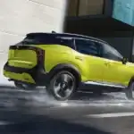 2027 nissan kicks side profile driving down wet city road