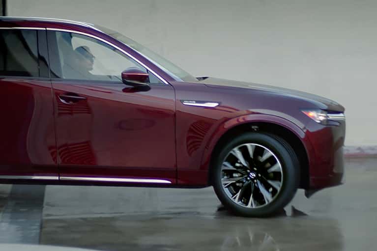 2024 Mazda CX-90 driving out of a garage