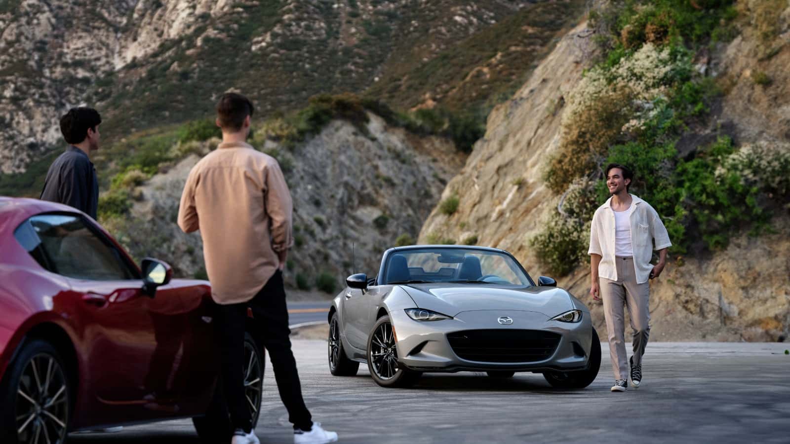 2026 Mazda MX-5 Miata on a mountain road with two people nearby