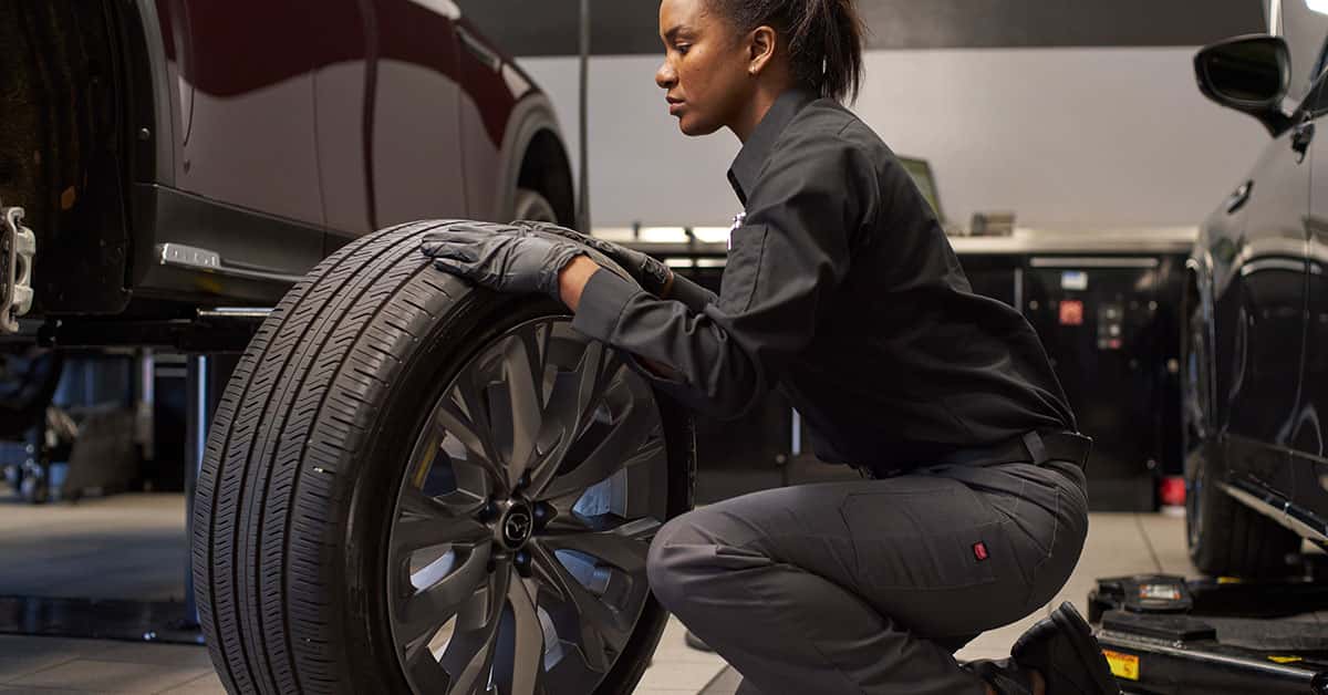 Mazda service technician rotating tires