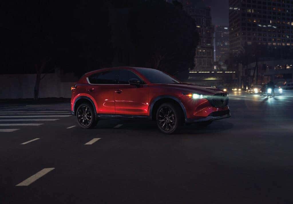 Red 2025 Mazda CX-5 driving on street at night
