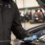 Mazda service technician changing vehicle's oil