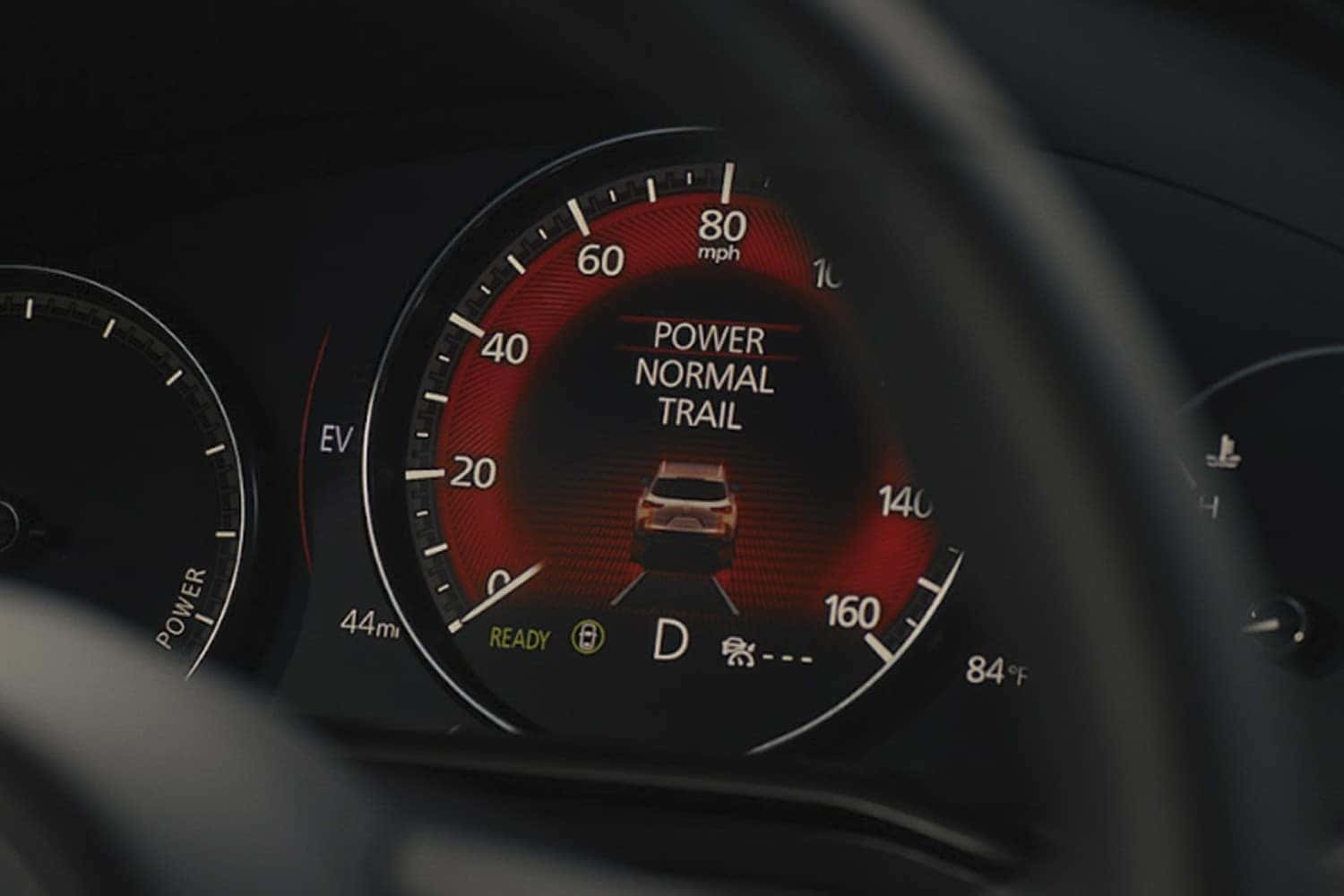 2026 Mazda CX-50 Hybrid driving on a scenic road demonstrating hybrid power and electronic all-wheel drive