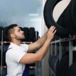 Mazda maintenance technician picking up a new tire