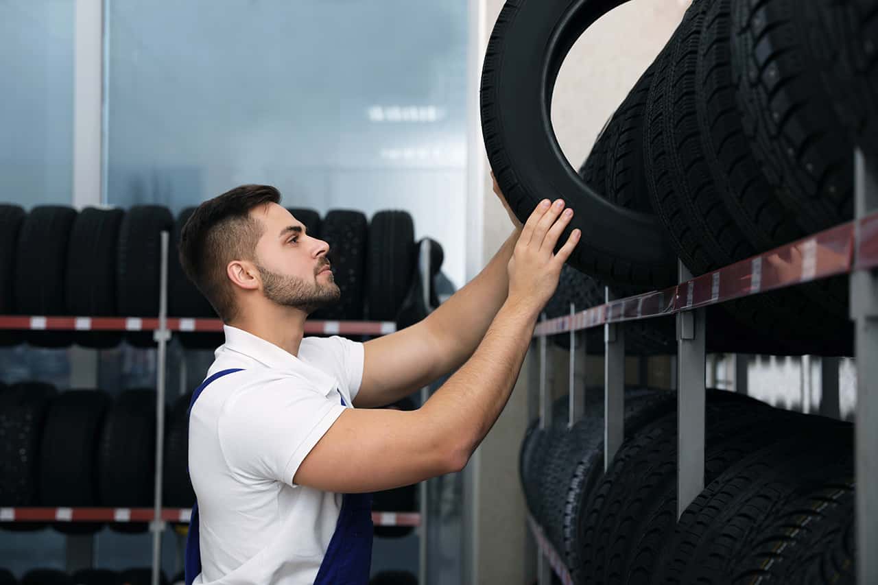 Mazda maintenance technician picking up a new tire