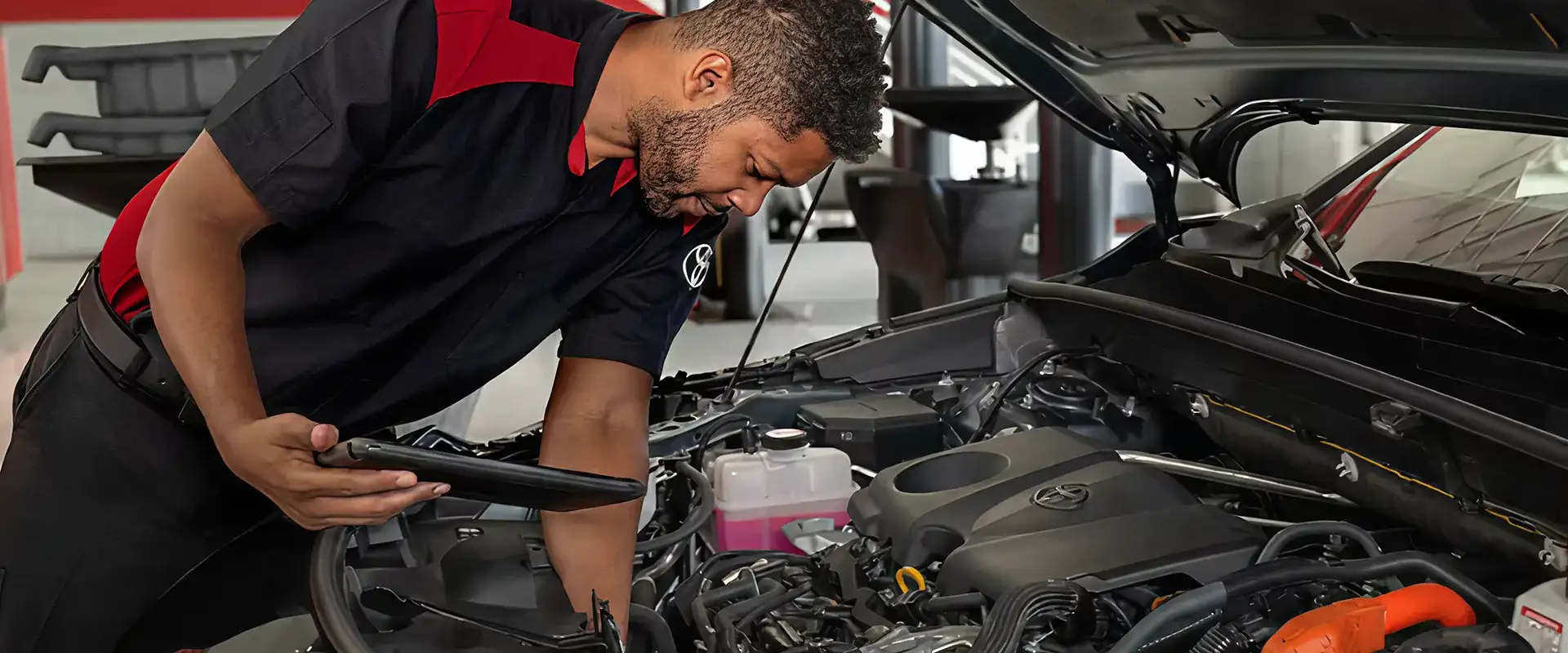 Toyota service center technician performing oil change