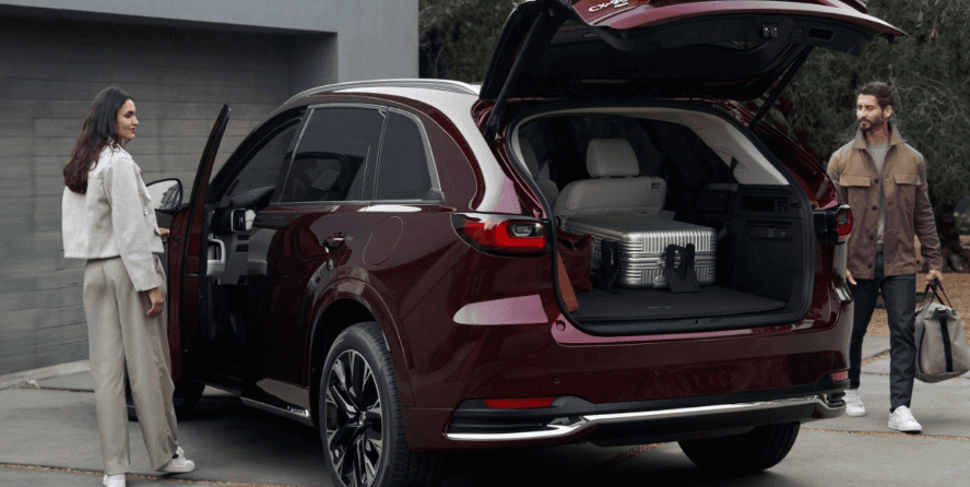 Couple standing next to a Mazda CX-90 for sale at Beaver Mazda in Cumming GA