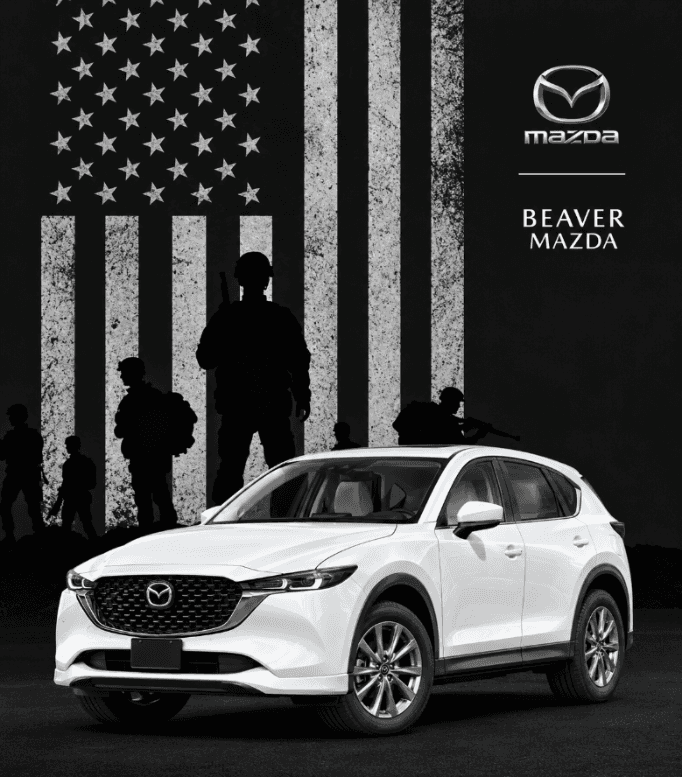 White Mazda SUV displayed in front of a distressed American flag with military silhouettes and Beaver Mazda branding