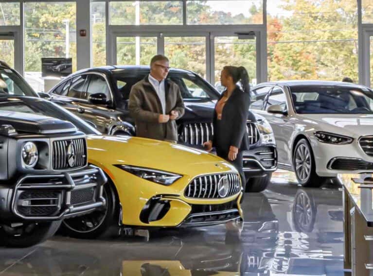 Sales consultant speaking to a customer in a luxury showroom - stress-free, no-pressure car buying, reputable
