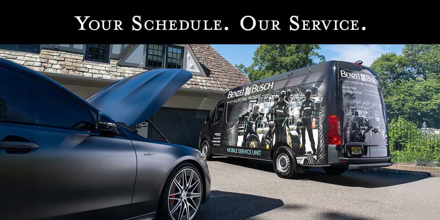 Benzel-Busch Mobile Service Unit van parked in a residential driveway next to a Mercedes-Benz with its hood open, with the headline 'Your Schedule. Our Service