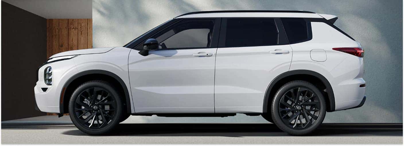 Profile view of a white 2026 Nissan Rogue PHEV with black alloy wheels and black exterior trim.