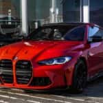 Red bmw m 3 coupe parked on gray concrete pavement during daytime