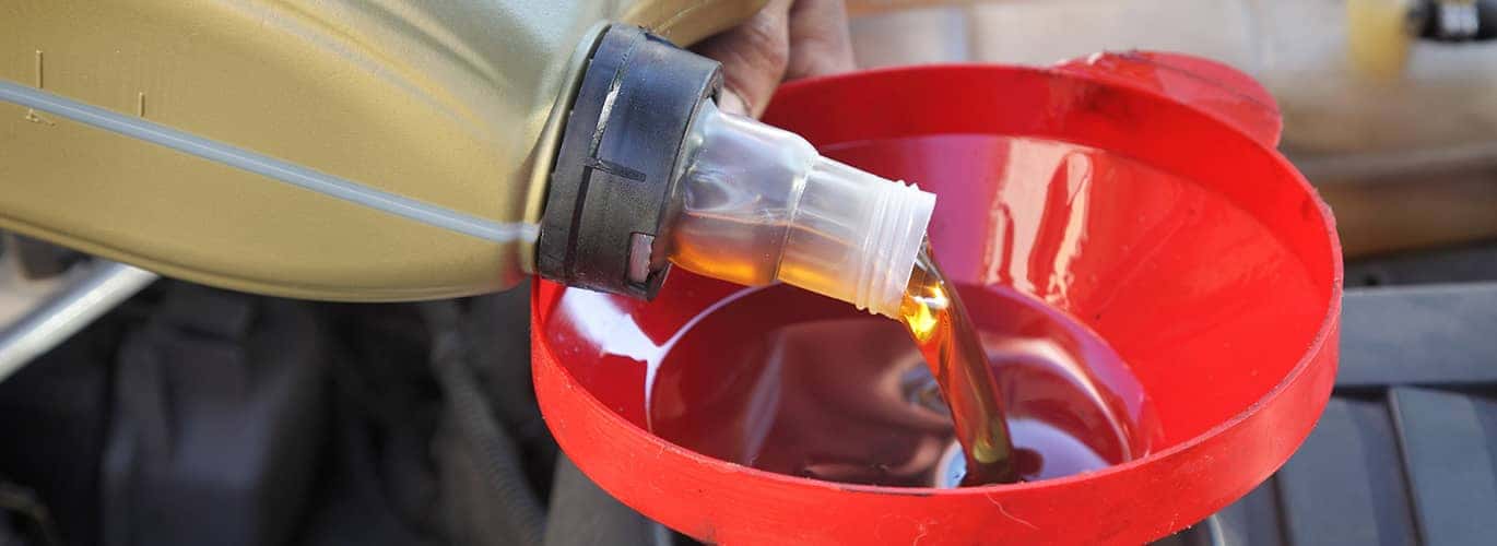 Oil picture of oil pouring into red funnel