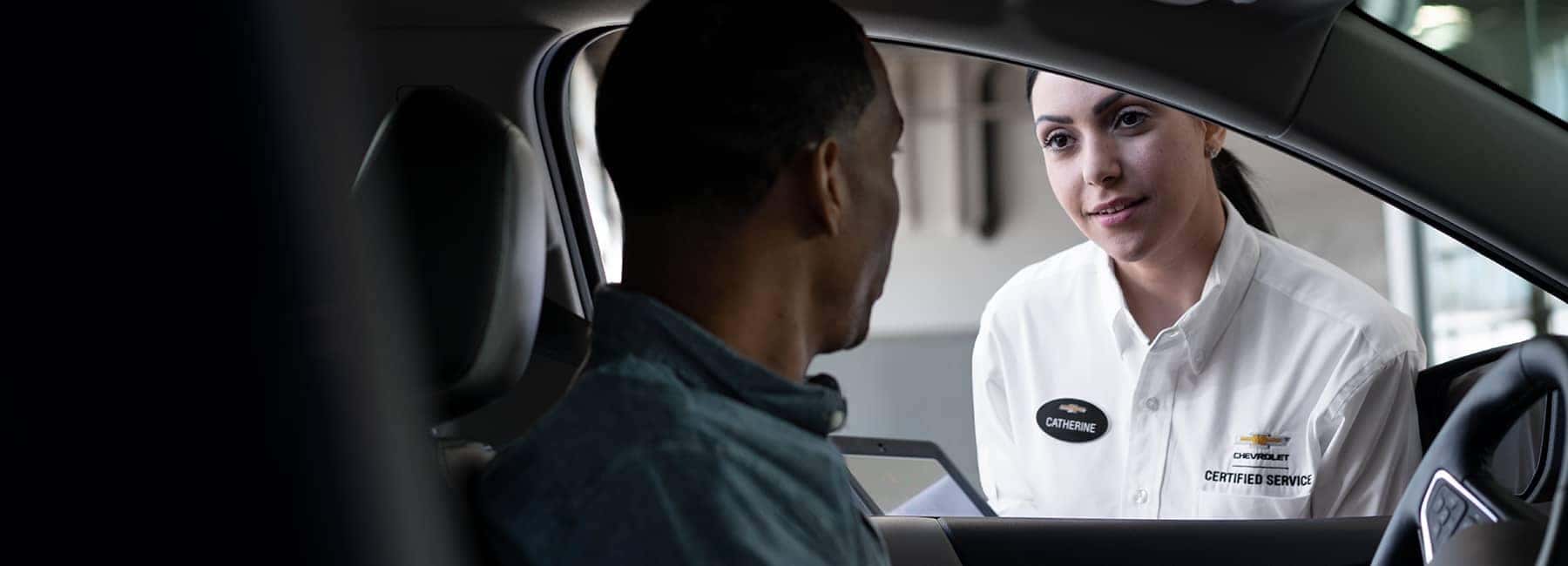 Chevrolet-service-technician-talking-with-man-sitting-in-car