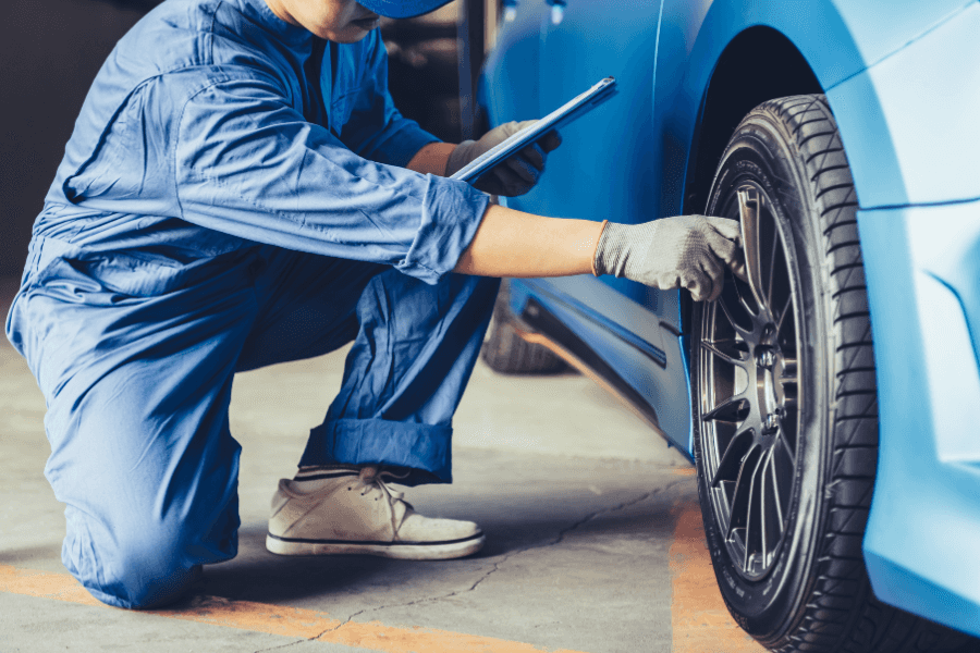 Car mechanic checking car tire