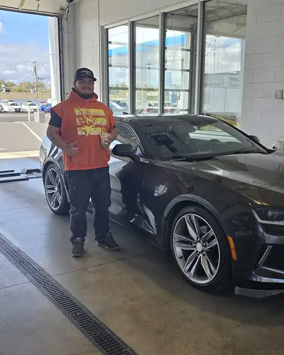A customer with his new car at a Bud Clary store