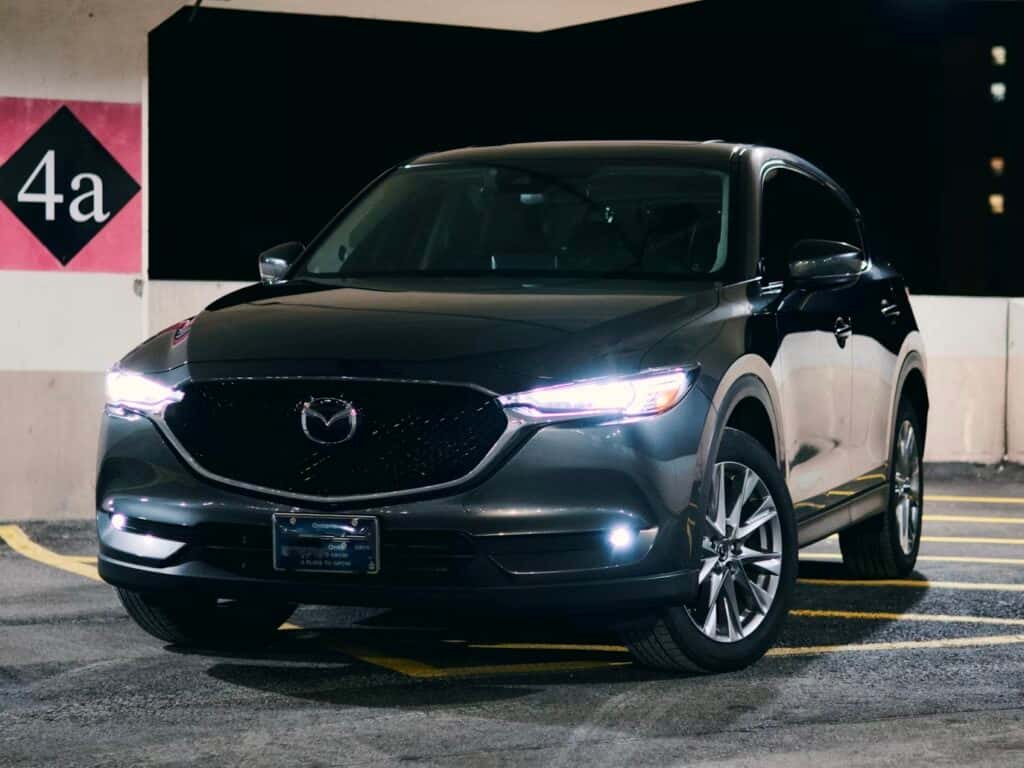 A black mazda suv is parked at night