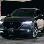 A black mazda suv is parked at night